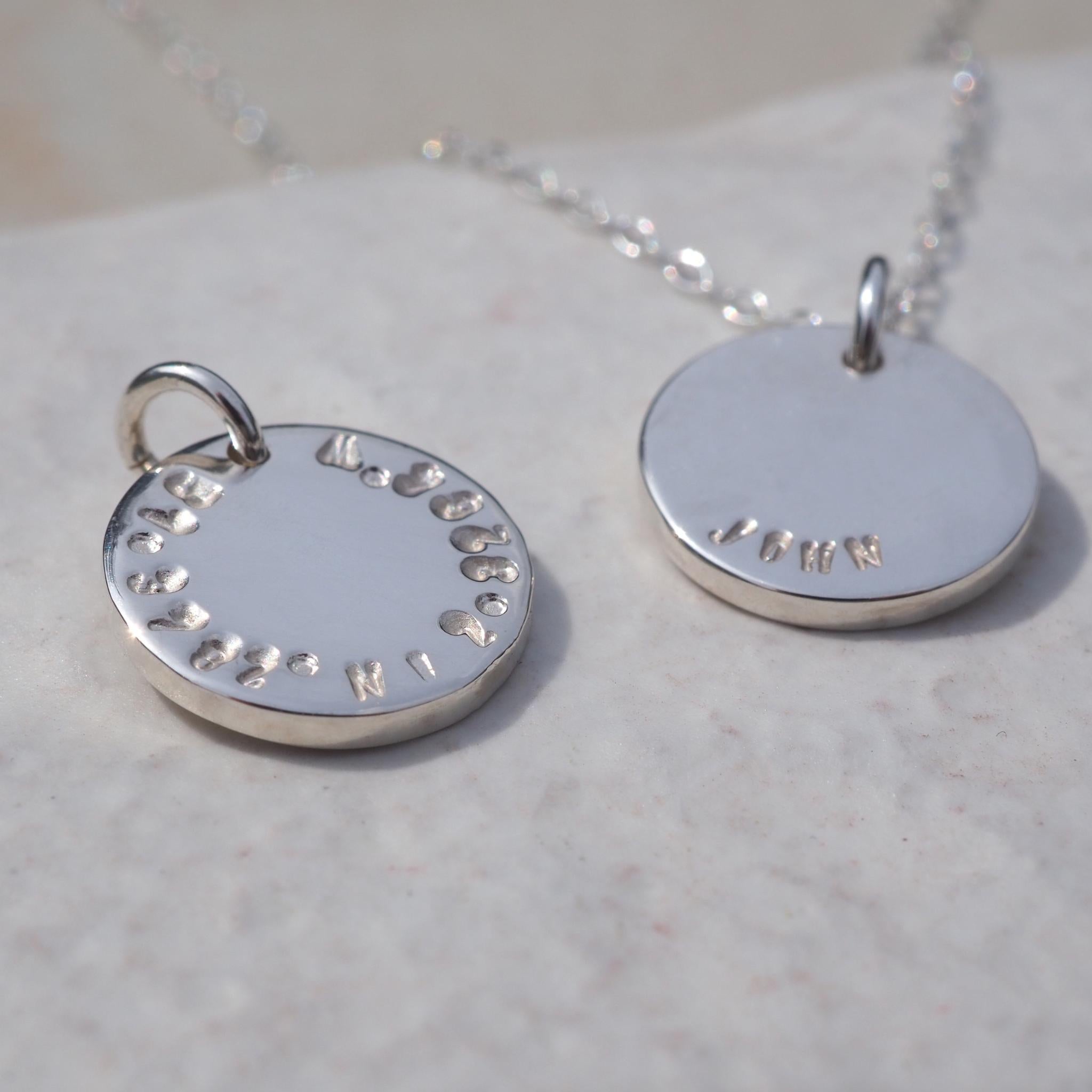 Double-sided disc necklace in sterling silver, personalised with a name on one side and grid reference on the other