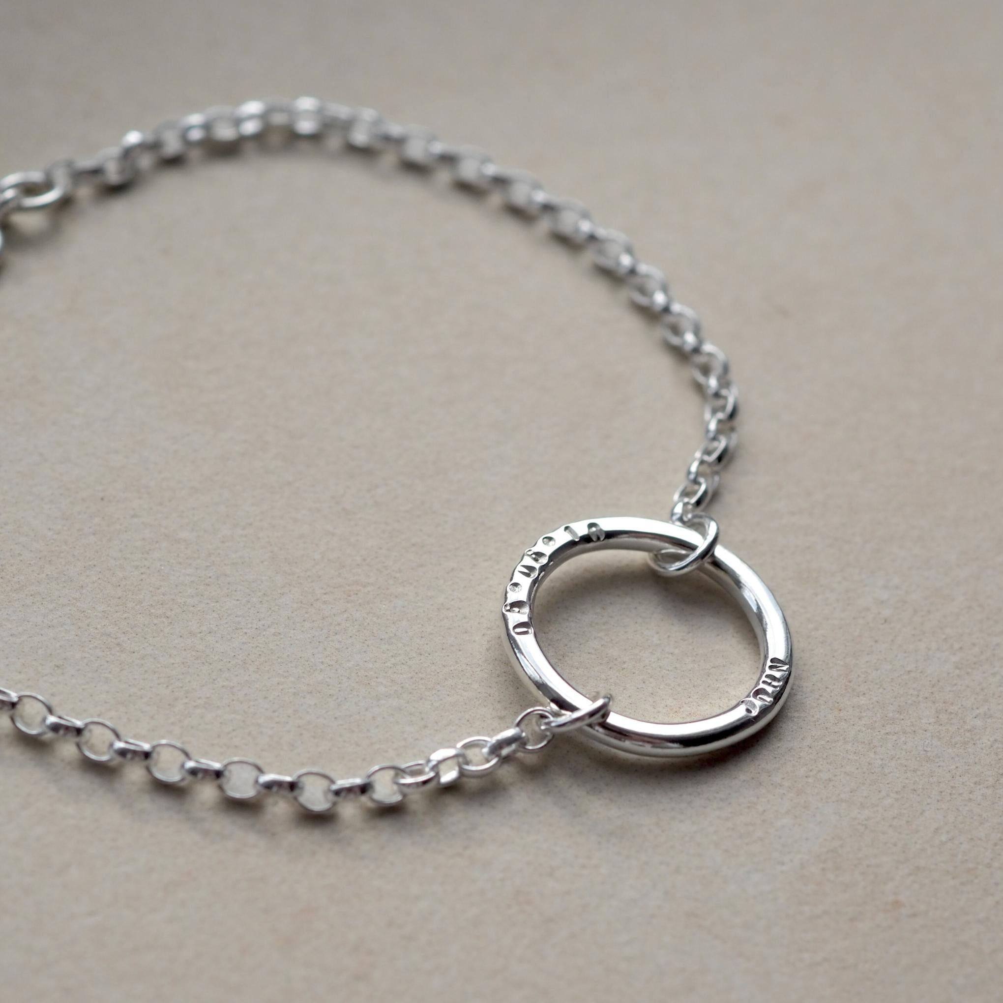 Close-up of a personalised Halo Bracelet, customised with a handstamped name and date
