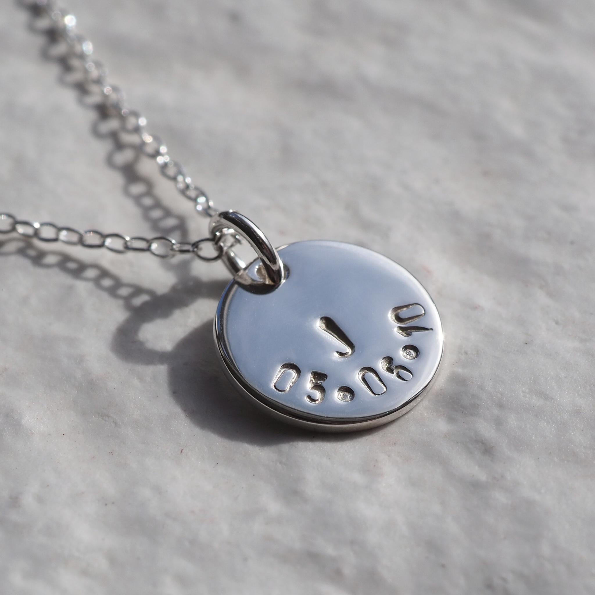 Hand stamped disc necklace with an initial and date