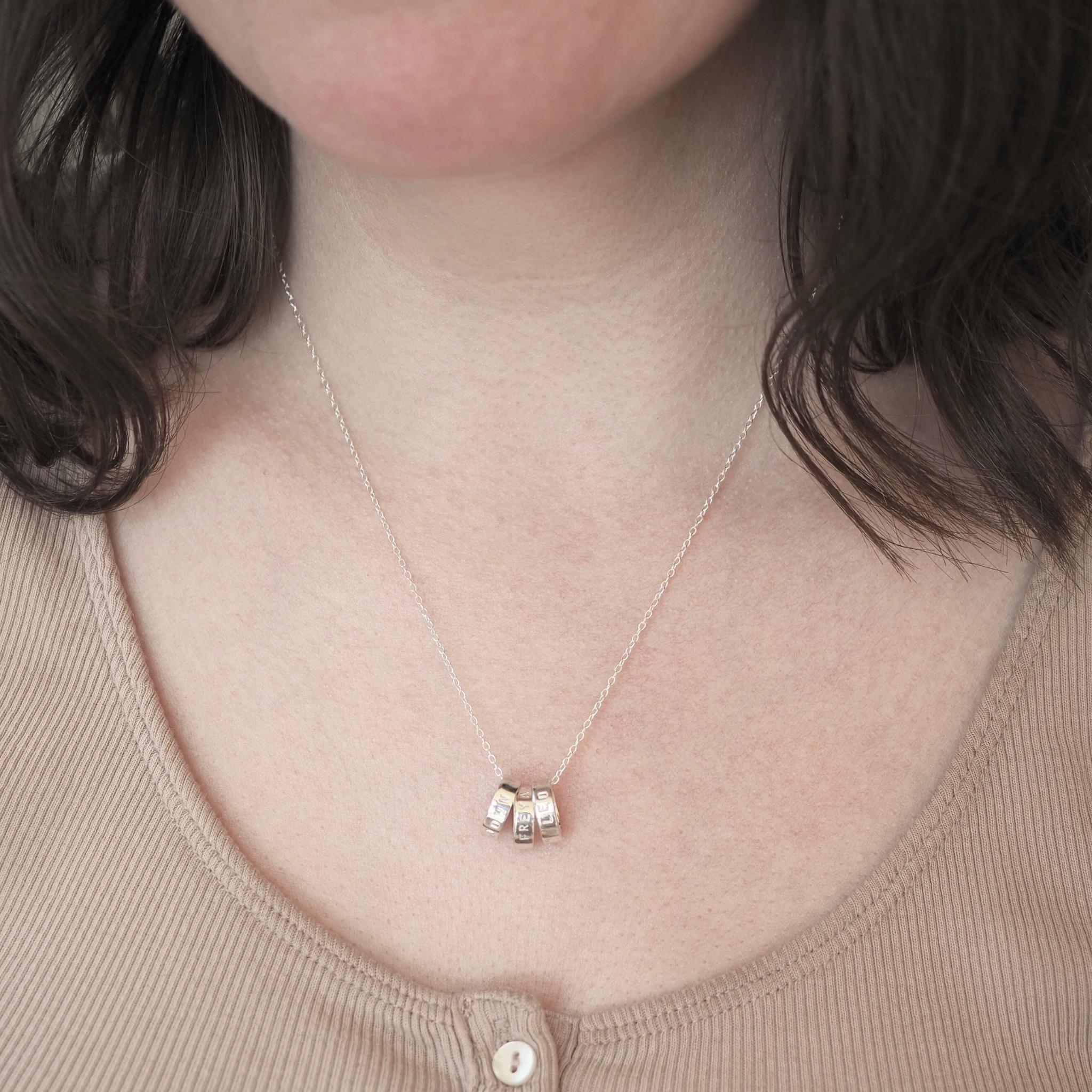 Model wearing a personalised triple scroll necklace in sterling silver