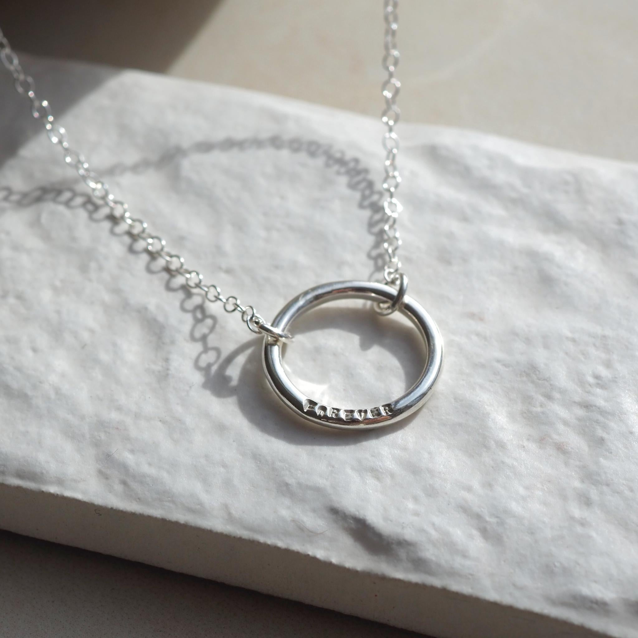 Personalised single halo necklace in sterling silver with hand-stamped text